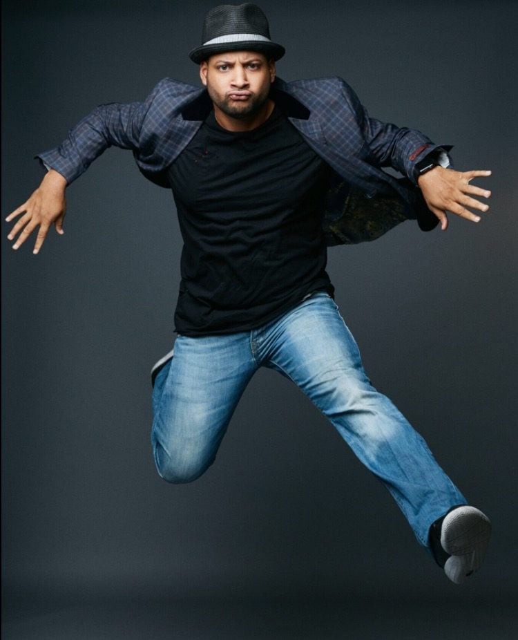 Dynamic man jumping in studio against dark background, showcasing energy and enthusiasm, suitable for fitness, fashion, or lifestyle branding.