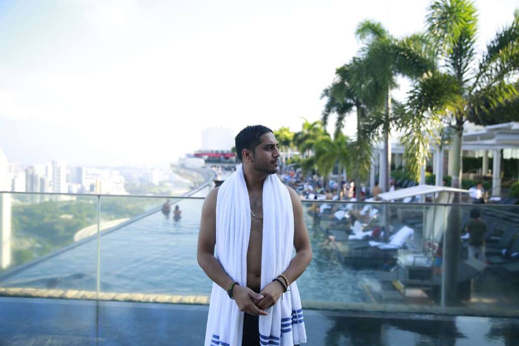 Paul beside the rooftop infinity pool at Marina Bay Sands with Singapore behind him