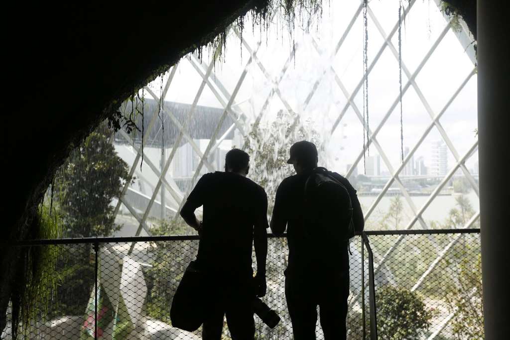 Visitors silhouetted beside the indoor waterfall inside Gardens by the Bay's Cloud Forest