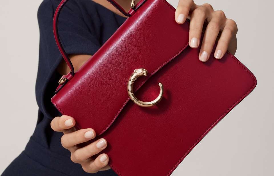 Model carrying a burgundy Panthère C de Cartier handbag