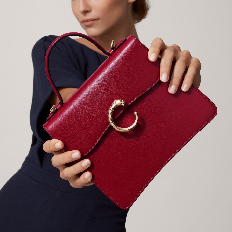 Model carrying a burgundy Panthère C de Cartier handbag
