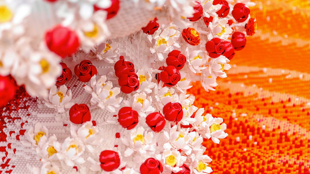 White and red LEGO flowers forming the crest of an orange botanical wave