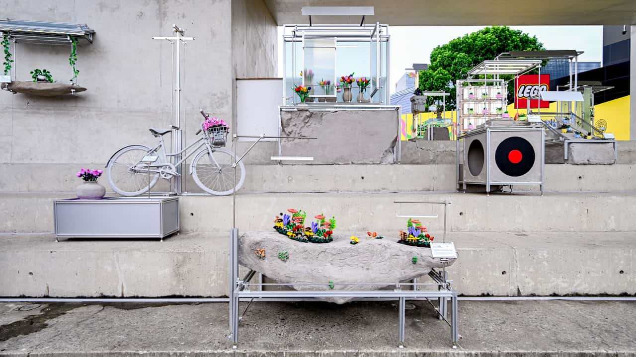 LEGO botanical arrangements displayed with a bicycle and furniture in a domestic setting