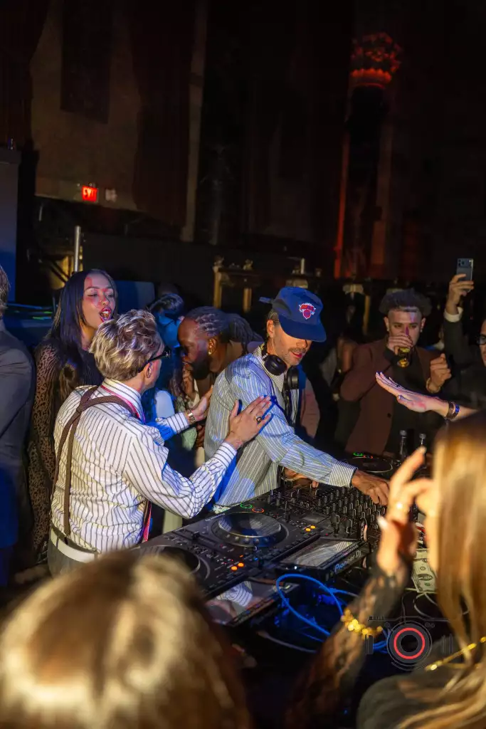 A DJ performs as guests gather around the booth at Drake’s birthday celebration.