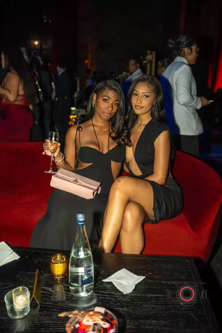 Two guests sit together inside Casa Cipriani during Drake’s birthday celebration.