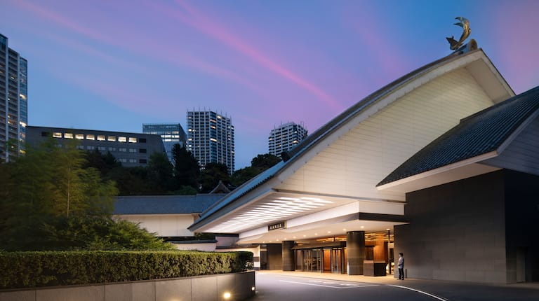 The illuminated entrance to Gajoen Tokyo, showing its traditional Japanese roofline and contemporary hotel exterior
