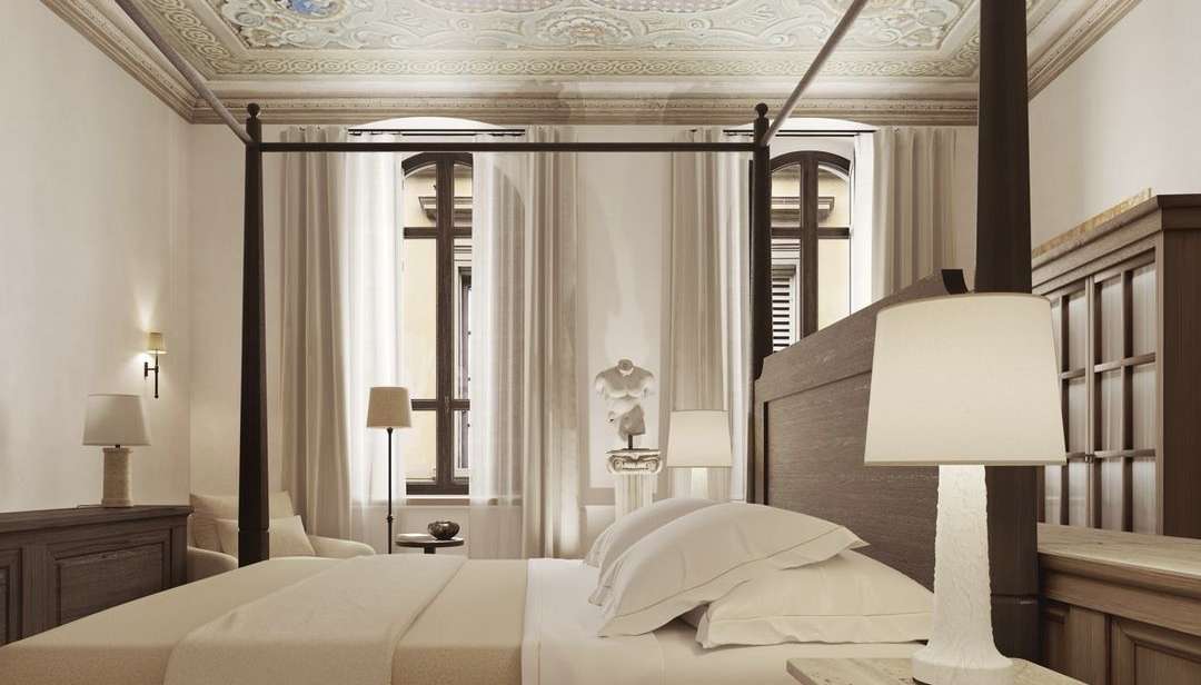 La Réserve Firenze apartment bedroom with four-poster bed and restored decorative ceiling