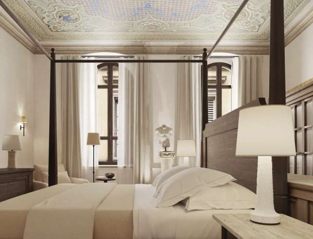 La Réserve Firenze apartment bedroom with four-poster bed and restored decorative ceiling