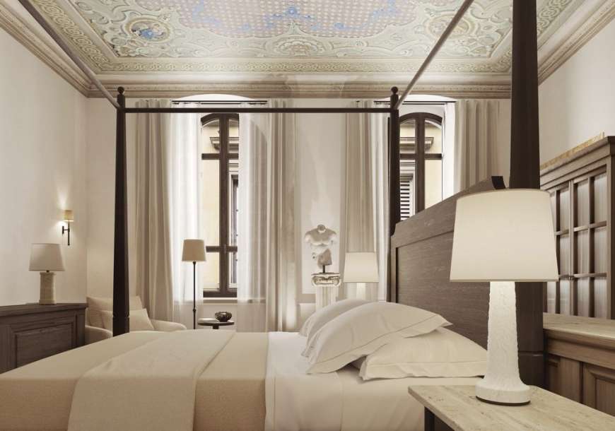 La Réserve Firenze apartment bedroom with four-poster bed and restored decorative ceiling
