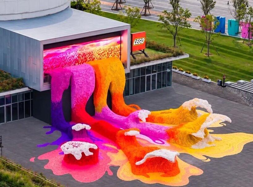 Elevated view of colourful LEGO flower waves spreading from a former oil tank