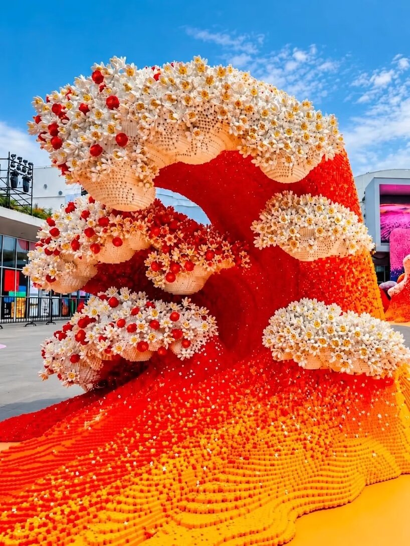 Red and orange LEGO wave crowned with white brick-built flowers