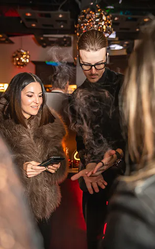 Roman Royss performing a smoke illusion at a brand event