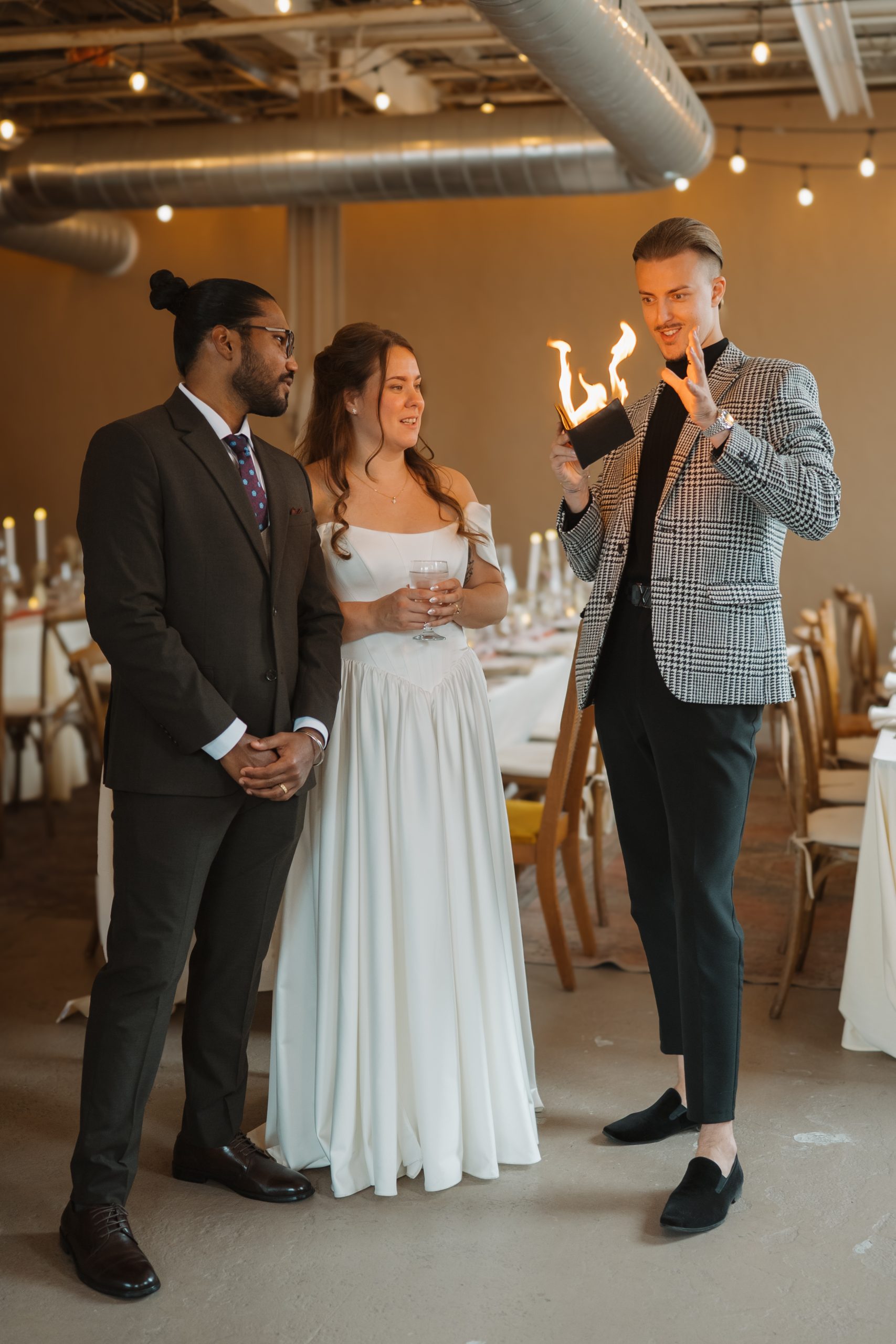 Roman Royss holding a flame beside a bride and groom